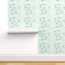 Load image into Gallery viewer, Fish shapes in various sizes on a pale green background on a mock wall with wallpaper rolls
